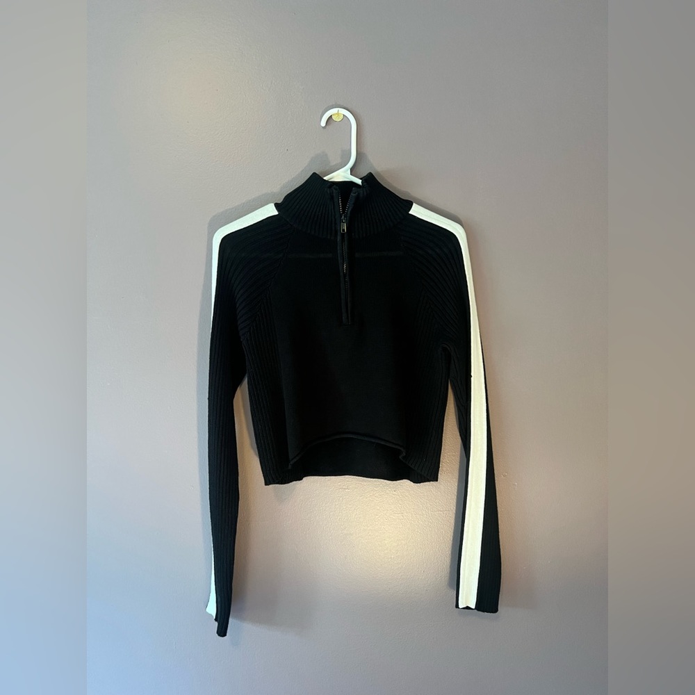 Black and with white stripes, cropped, turtle neck top.